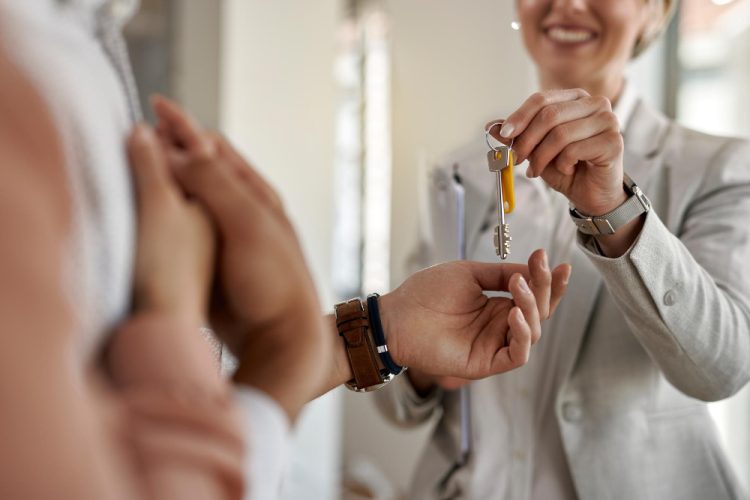 primer-plano-pareja-que-recibe-llaves-su-nuevo-apartamento-agente-inmobiliario
